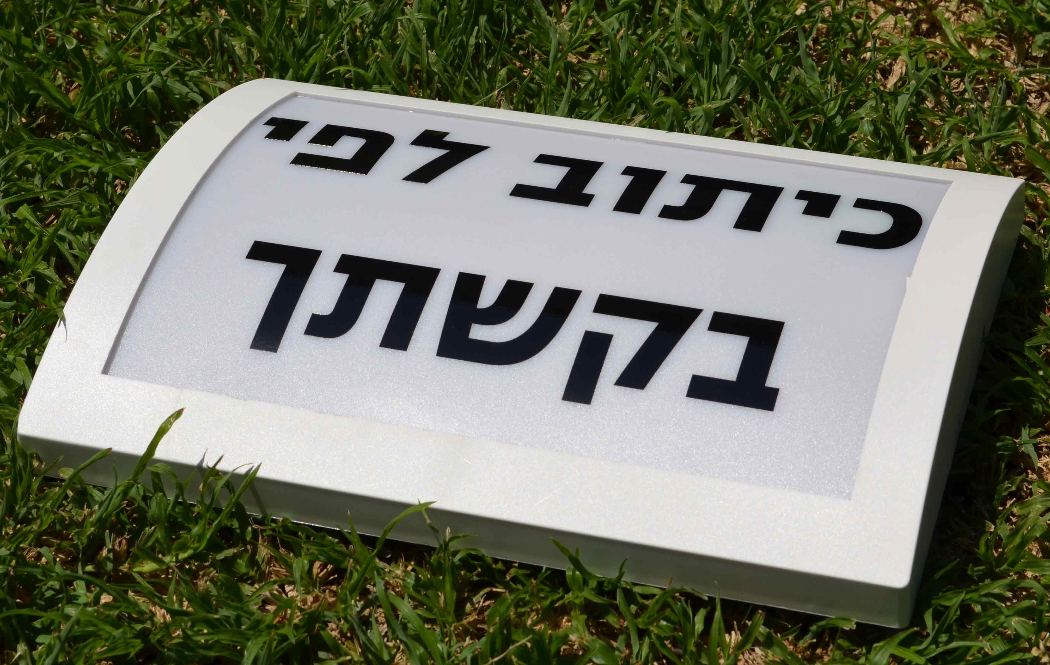 כיתוב על גבי שלט מואר לבית